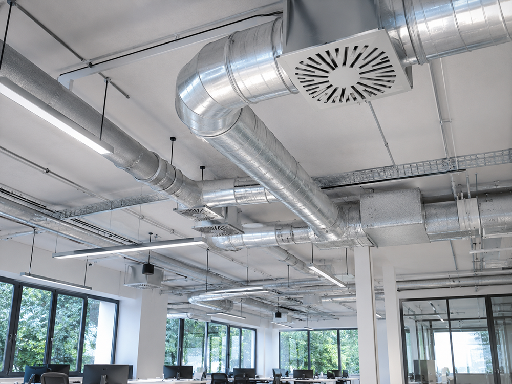 Lüftungsanlage mit Luftkanälen und Luftauslass Moderne Lüftungsanlage mit Luftkanälen und Luftauslässen in einem Bürogebäude als Beispiel für Lüftungsplanung und Klimatechnik