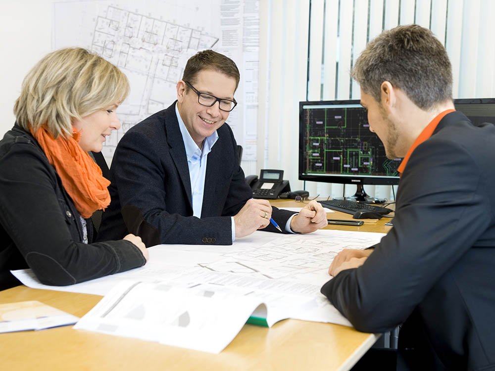 Beratung zur TGA-Planung im Ingenieurbüro Beratungsgespräch mit Bauplänen im Ingenieurbüro für technische Gebäudeausrüstung, Heizung, Sanitär, Lüftung und Elektro
